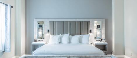 Een moderne slaapkamer met een groot bed, nachtkastjes en een vastgezet hoofdbord.