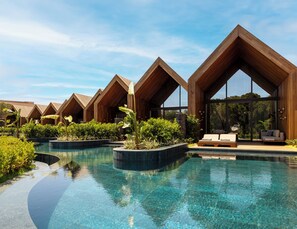 A resort with multiple wooden cabins, a central pool, and lush greenery. - Kempinski Hotel The Dome Belek - All Inclusive (Serik)
