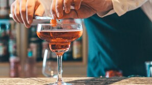 Un barman préparant un cocktail dans un bar.