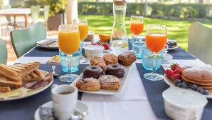 A breakfast table with various pastries, fruits, and beverages.