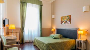 Une chambre d’hôtel avec un lit, un bureau, une chaise et un tableau au mur.