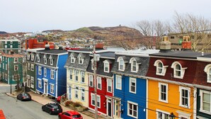 A row of colorful townhouses with a hilly backdrop. - Gower Guest House (St. John's)