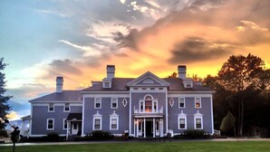 A large, two-story building with a symmetrical facade, central entrance, and multiple chimneys. - Kemble Inn (Lenox)