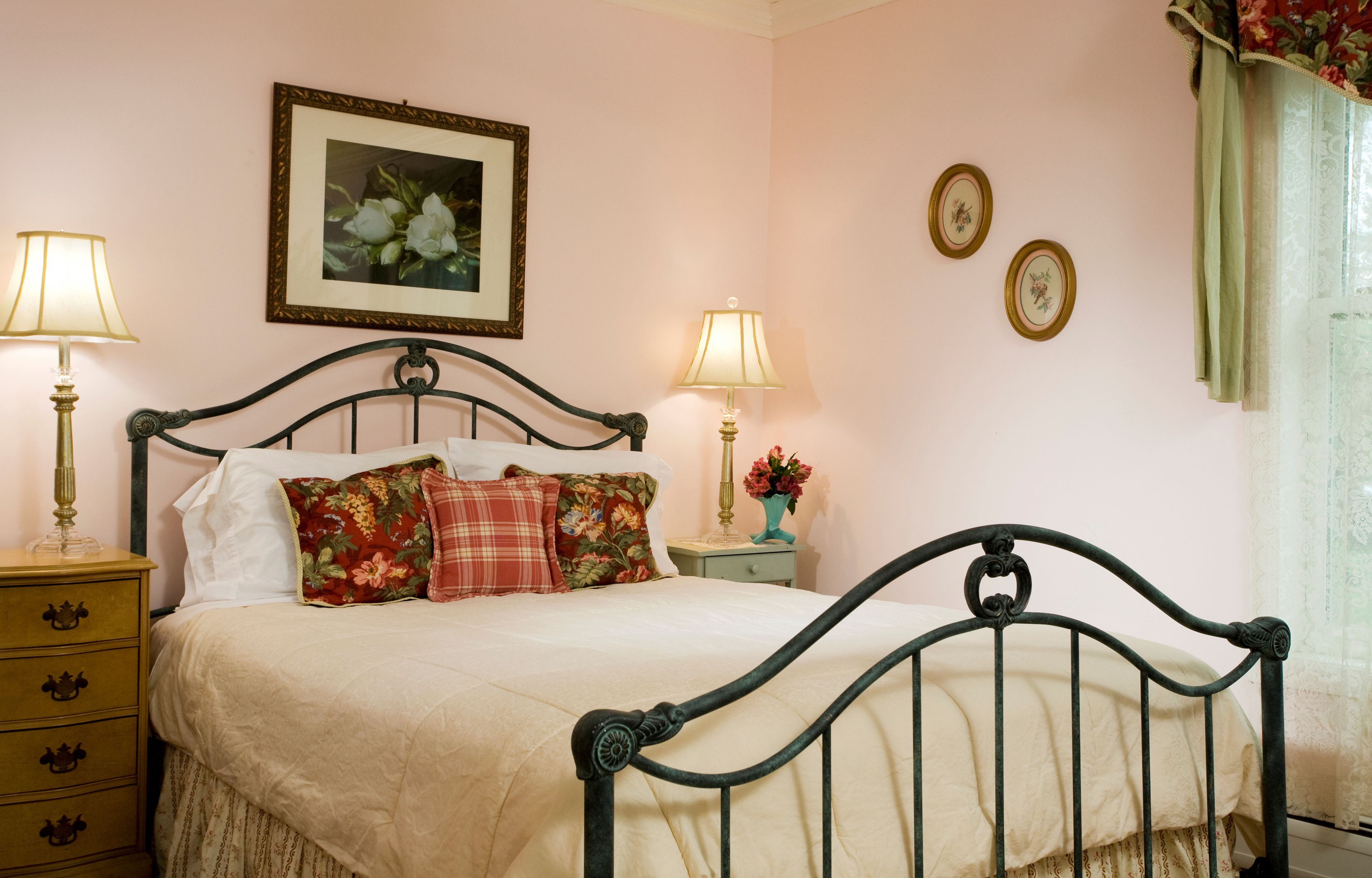 Un dormitorio con una cama, dos mesitas de noche y una lámpara de pared.