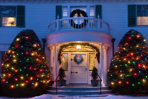 A house with a porch, two Christmas trees, and a wreath on the door. - Hampton Terrace Inn (Lenox)