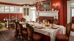A dining room with a large table set for a meal, surrounded by ornate chairs. - Hampton Terrace Inn (Lenox)