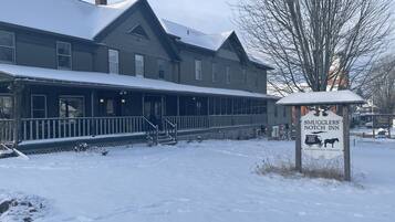 Un edificio de dos pisos con un porche y un cartel que dice 'Smugglers' Notch Inn' al frente.