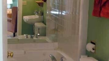 A bathroom with a bathtub, toilet, and sink.
