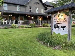 A sign for Smugglers' Notch Inn, featuring a horse-drawn carriage illustration.