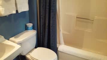 A bathroom with a toilet, sink, and shower.