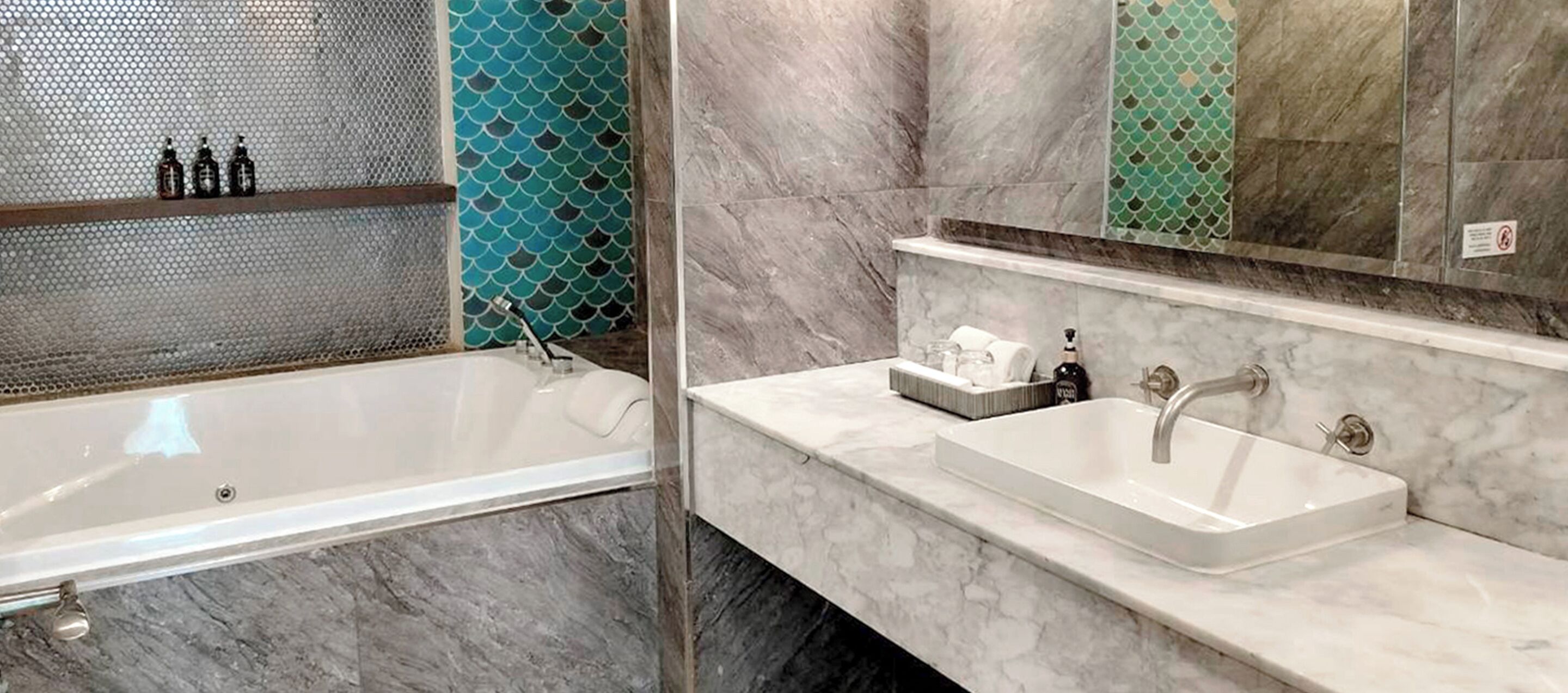A modern bathroom with a bathtub, a sink, and a shower area.