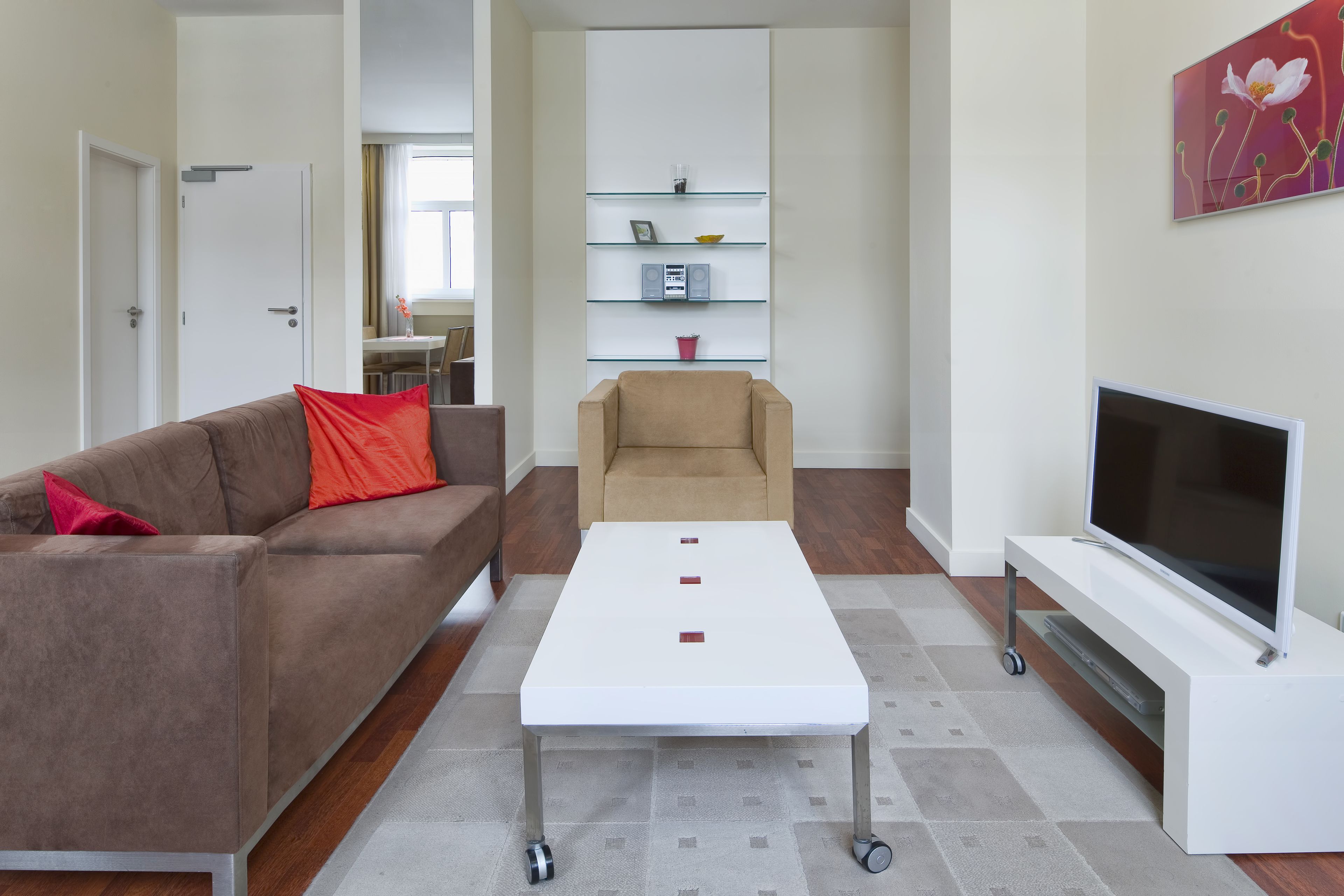 A modern living room with a sofa, a coffee table, a TV, and a bookshelf.
