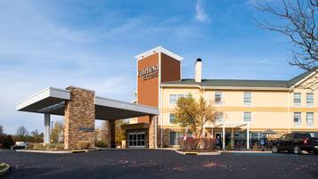 A Fairfield Inn & Suites hotel with a covered parking area and a brick facade.