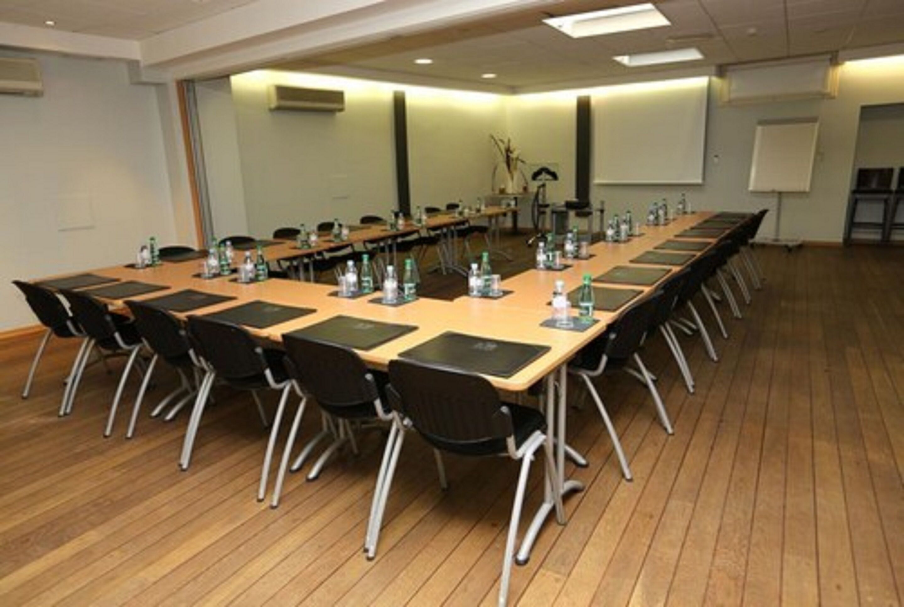 A conference room with a long table, chairs, and a whiteboard.