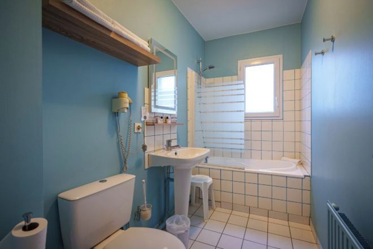 Une salle de bain avec des toilettes, un lavabo et une baignoire.