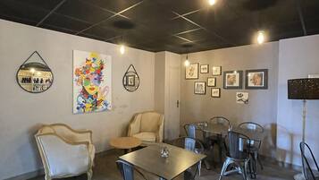 Une salle de conférence avec une longue table, plusieurs chaises, un canapé et des œuvres d’art murales.