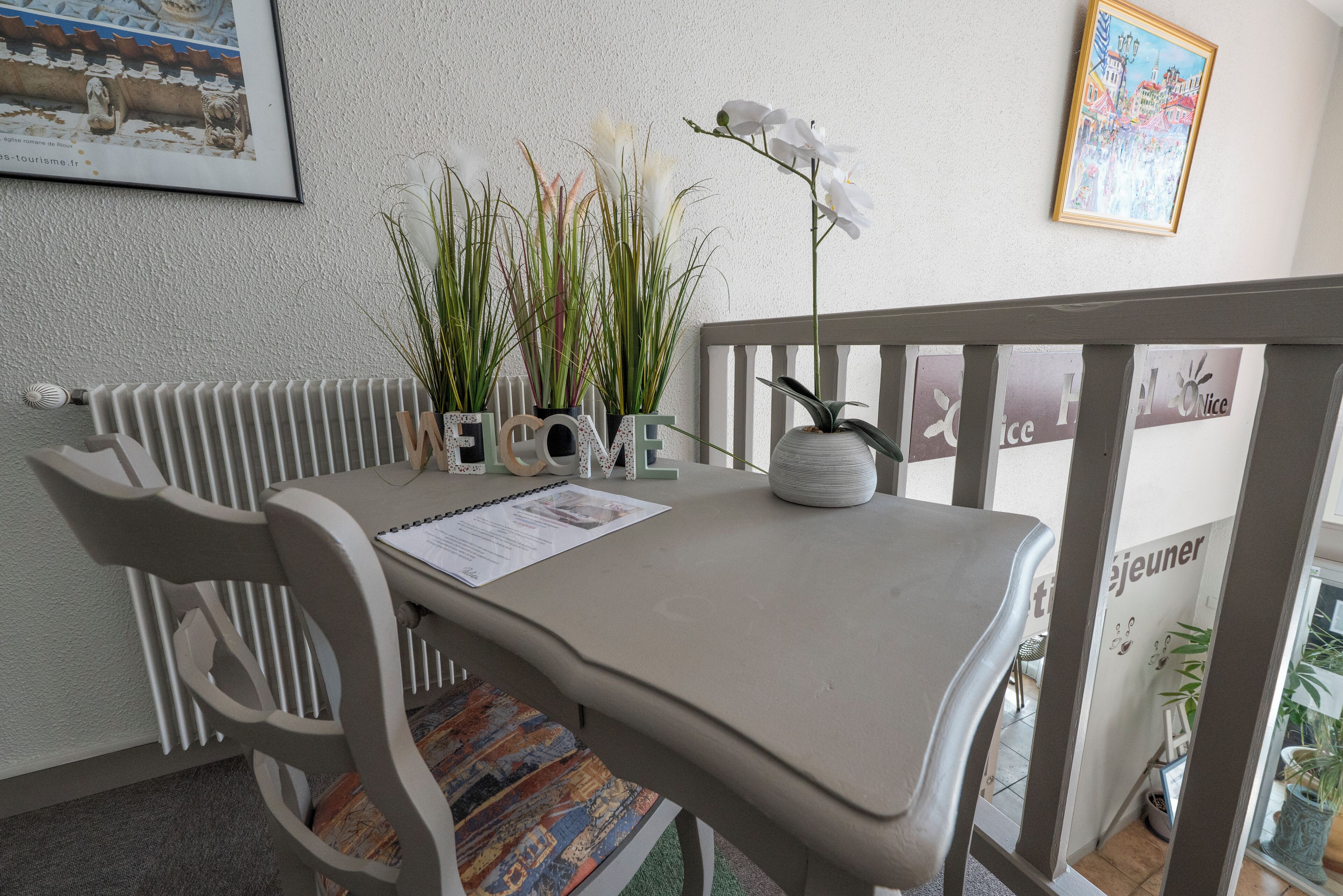 Un comedor con una mesa, sillas y una planta en maceta.