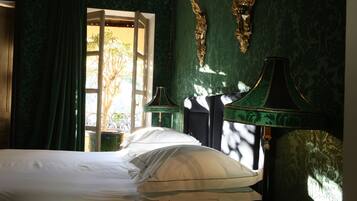 A room with a bed, a lamp, and a window with curtains.