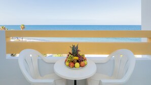 A balcony with a table and chairs, overlooking a beach and the ocean. - Marhaba Royal Salem (Sousse)