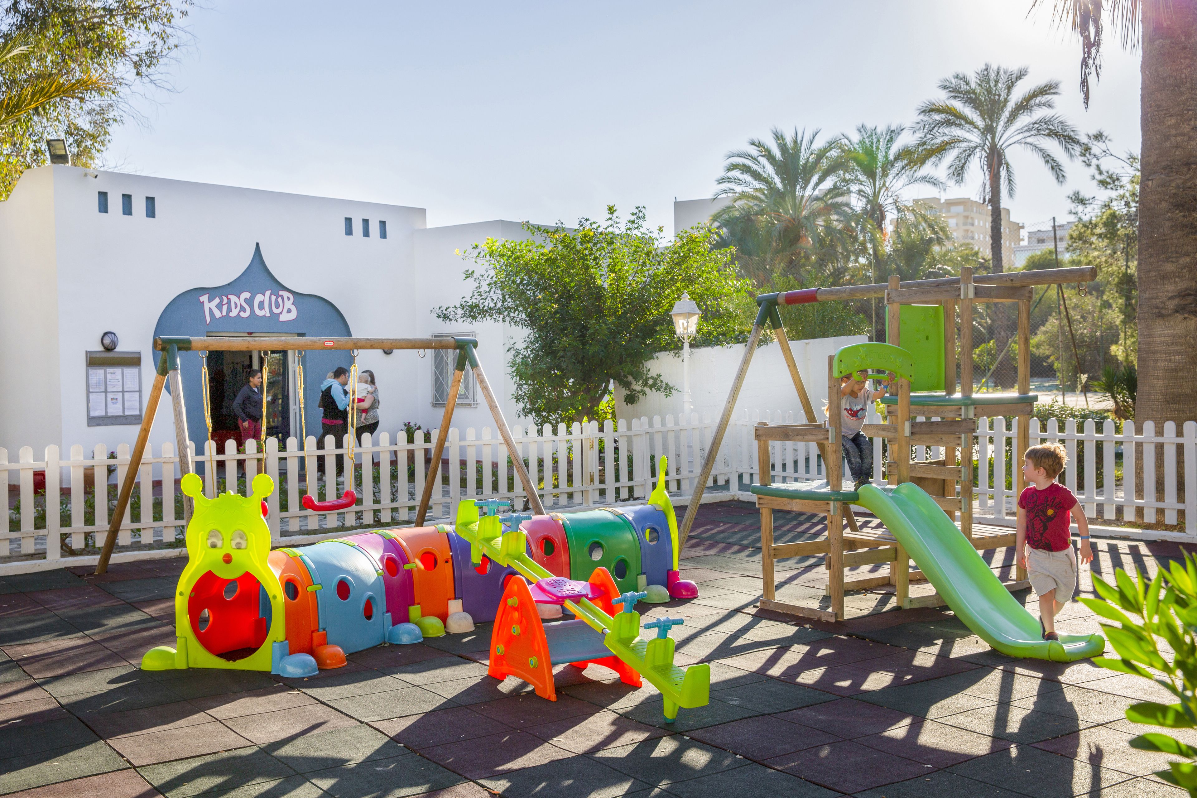 A playground with colorful play structures and a swing set.