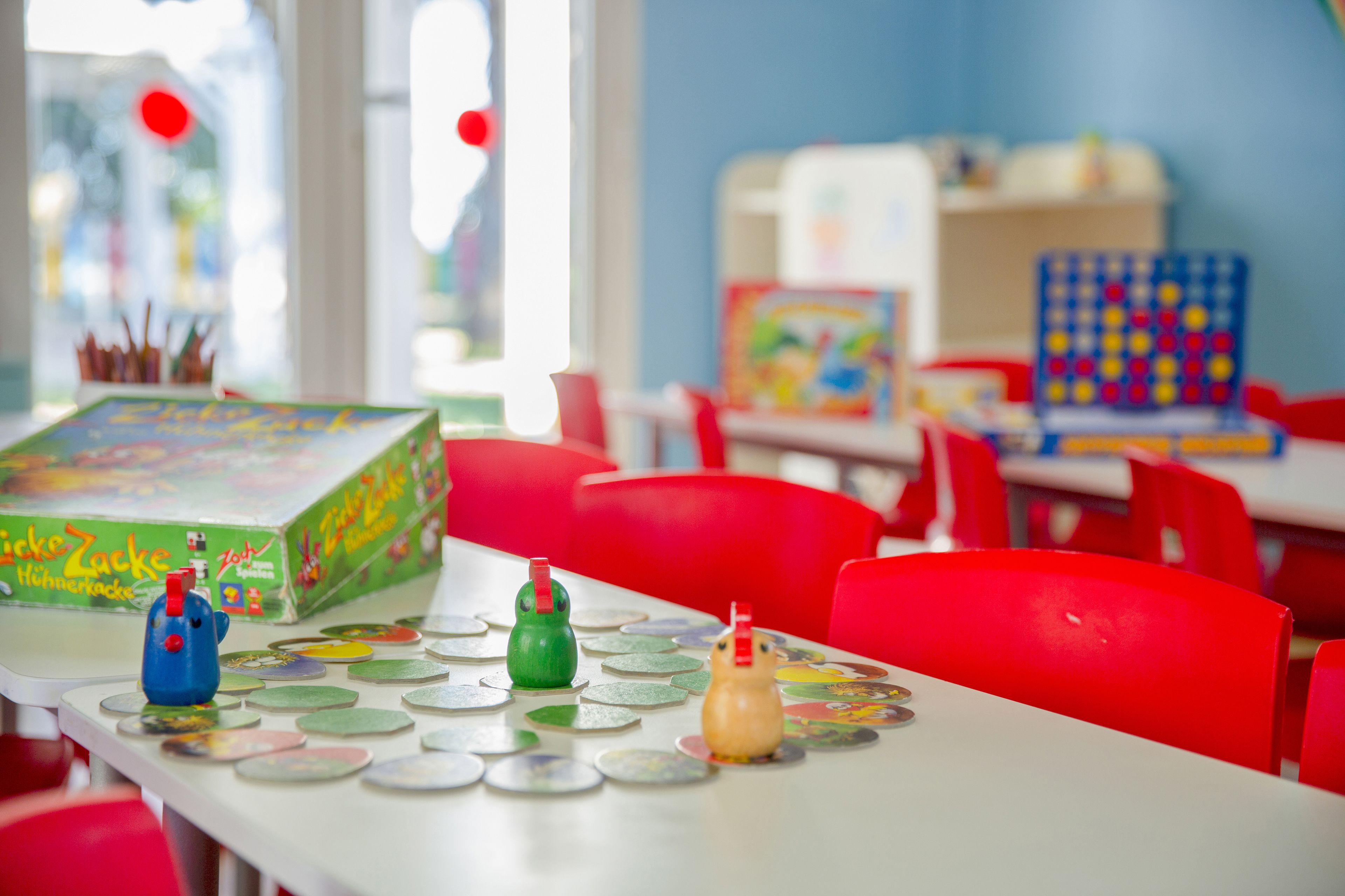 Un espace de jeux pour enfants avec une table aménagée pour un jeu, comprenant des pièces de jeu colorées et une boîte de jeu.