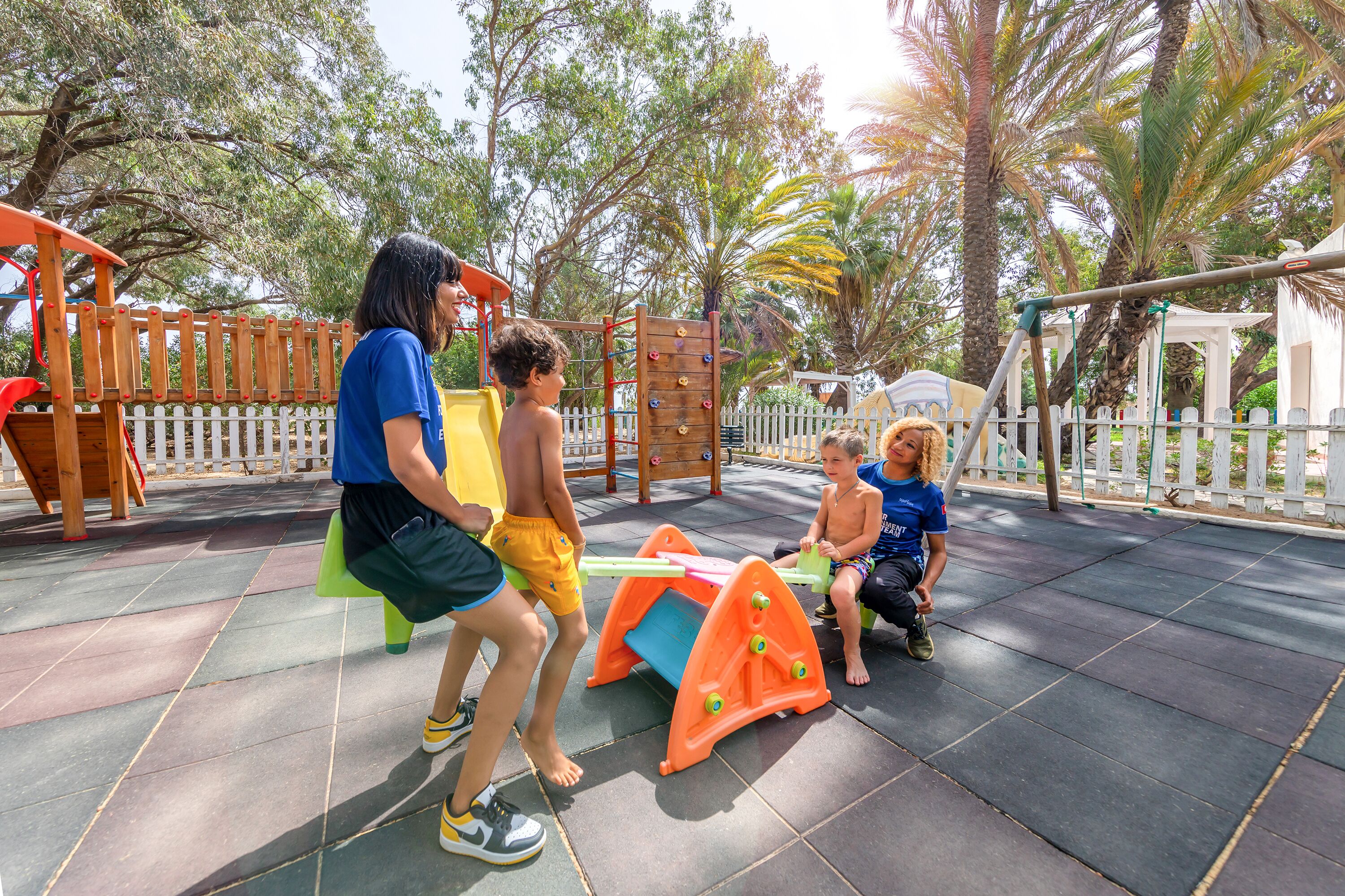 A playground with a slide, climbing structures, and a seating area.