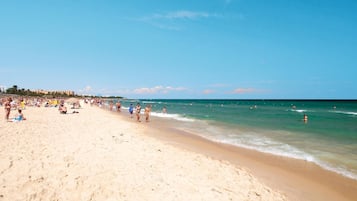Playa privada, arena blanca, sillas reclinables de playa, sombrillas