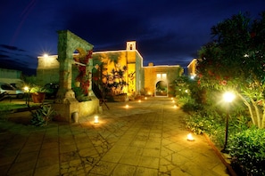 A historic building with a courtyard, stone walls, and potted plants. - Relais Masseria Casina Dei Cari (Presicce-Acquarica)