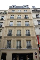 Un edificio de varios pisos con estilo arquitectónico clásico, que cuenta con balcones y ventanas amplias.