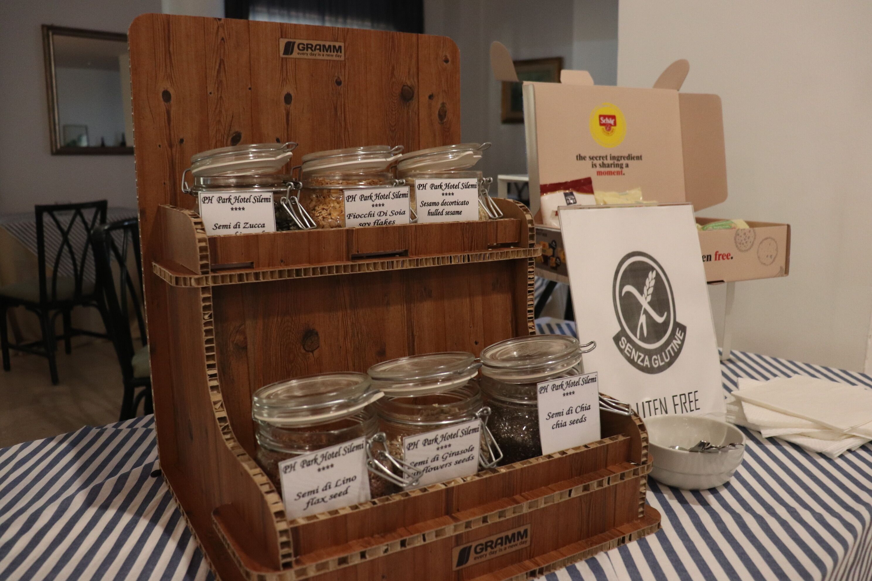 Un expositor de madera con frascos etiquetados con diferentes semillas y un letrero que indica productos sin gluten.