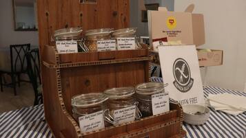 Un expositor de madera con frascos etiquetados con diferentes semillas y un letrero que indica productos sin gluten.