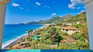 A coastal view with a beach, a pool, and a mountainous backdrop. - Park Hotel Silemi (Letojanni)