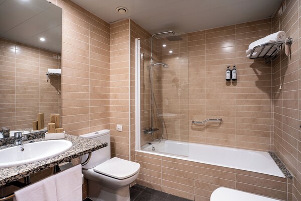 A modern bathroom with a sink, toilet, and bathtub. - Ponient Vila Centric by PortAventura World (Vila-Seca)