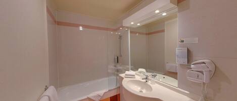 Une salle de bain moderne avec une baignoire, un lavabo et une douche à parois de verre.