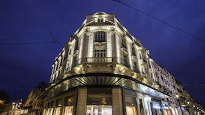 Un edificio histórico con una entrada imponente, varios pisos y un balcón.