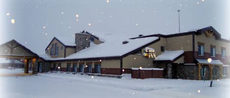 A snow-covered building with a sign that reads "Chom Inn."