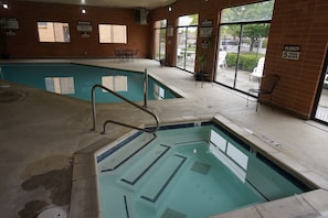 Relax by the pool surrounded by comfortable seating and large windows offering a view of the outside.