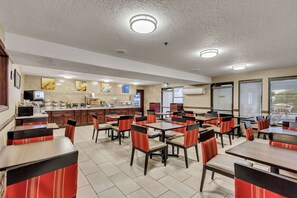 Enjoy dining in comfort with booths and tables, a counter area, and artwork-adorned walls.