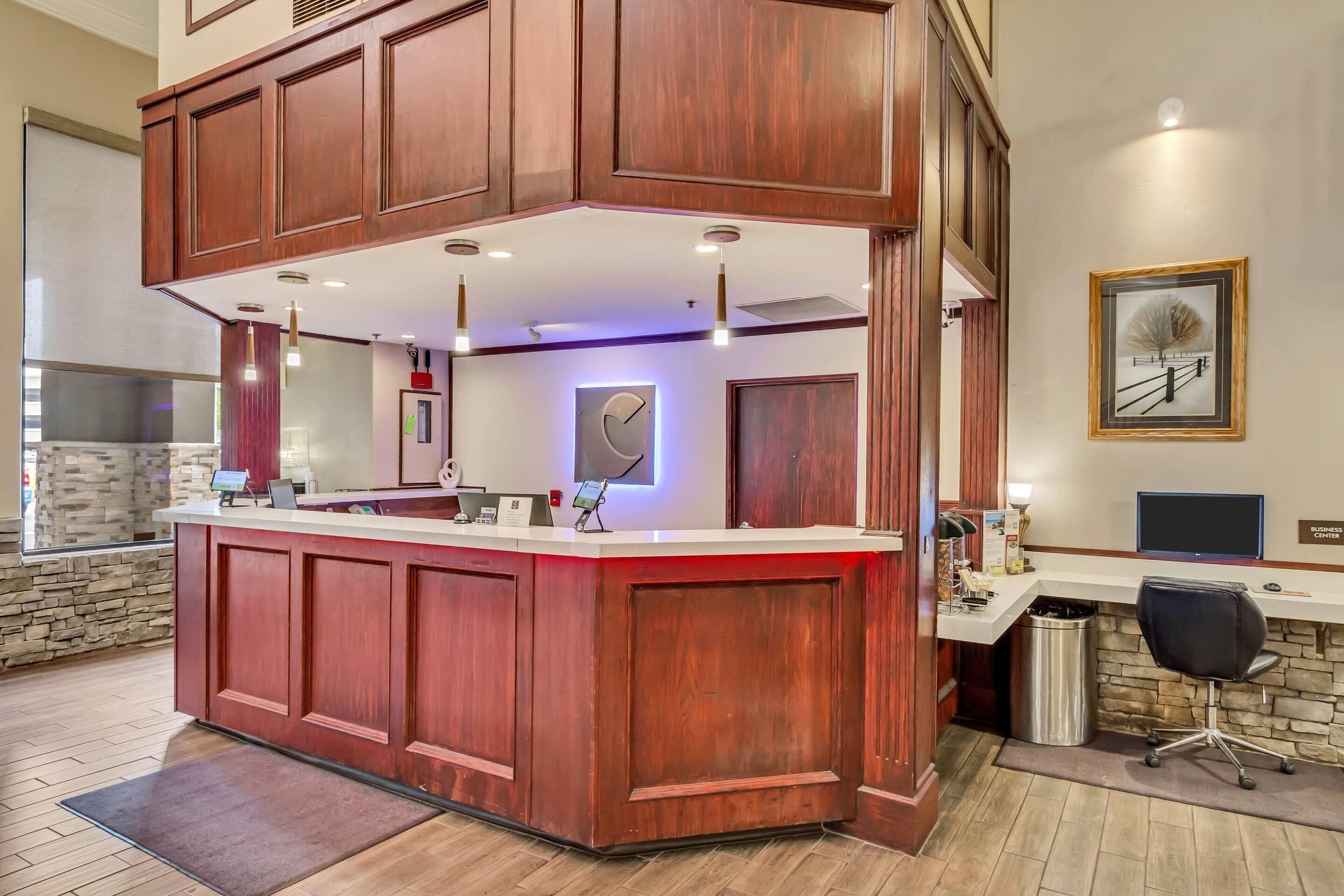 A reception area with a wooden counter, a clock, and a framed picture on the wall.