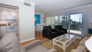 A living room with a sofa, a coffee table, and a dining area with chairs. - Gulfview Manor Resort (Fort Myers Beach)