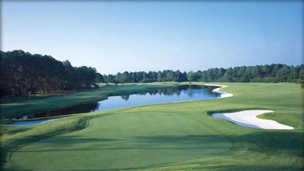 A golf course with a pond, sand bunkers, and a forested area. - Cottages on the Green (Pensacola)