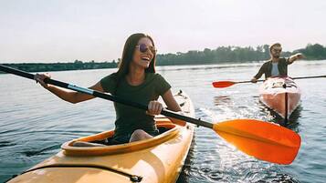 Two people kayaking on a calm body of water.