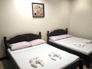 Two wooden beds with white linens and pink pillows, a framed artwork on the wall, and a towel on the floor. - Tubod Flowing Waters Resort (Talisay)