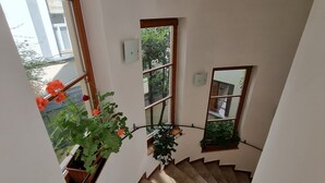 A staircase with a handrail, potted plants, and a view of the outside. - Hotel Claris (Prague)