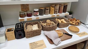 A bakery display with jars of jam, bread, and pastries. - Hotel Claris (Prague)