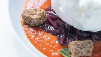 Un plato de postre con una bola de helado, un trozo de pastel y salsa roja.