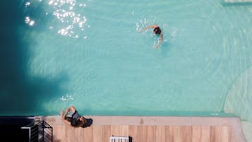 En säsongsöppen utomhuspool, parasoller och solstolar