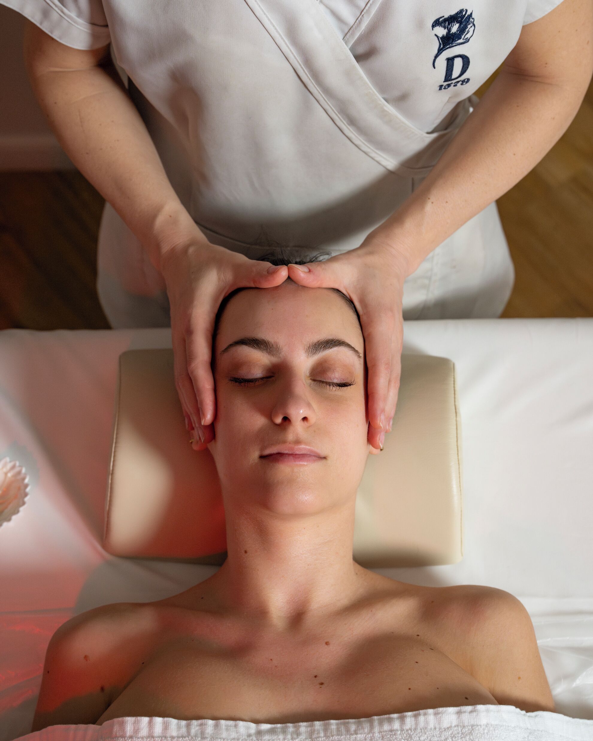 A person receiving a head massage on a massage table.