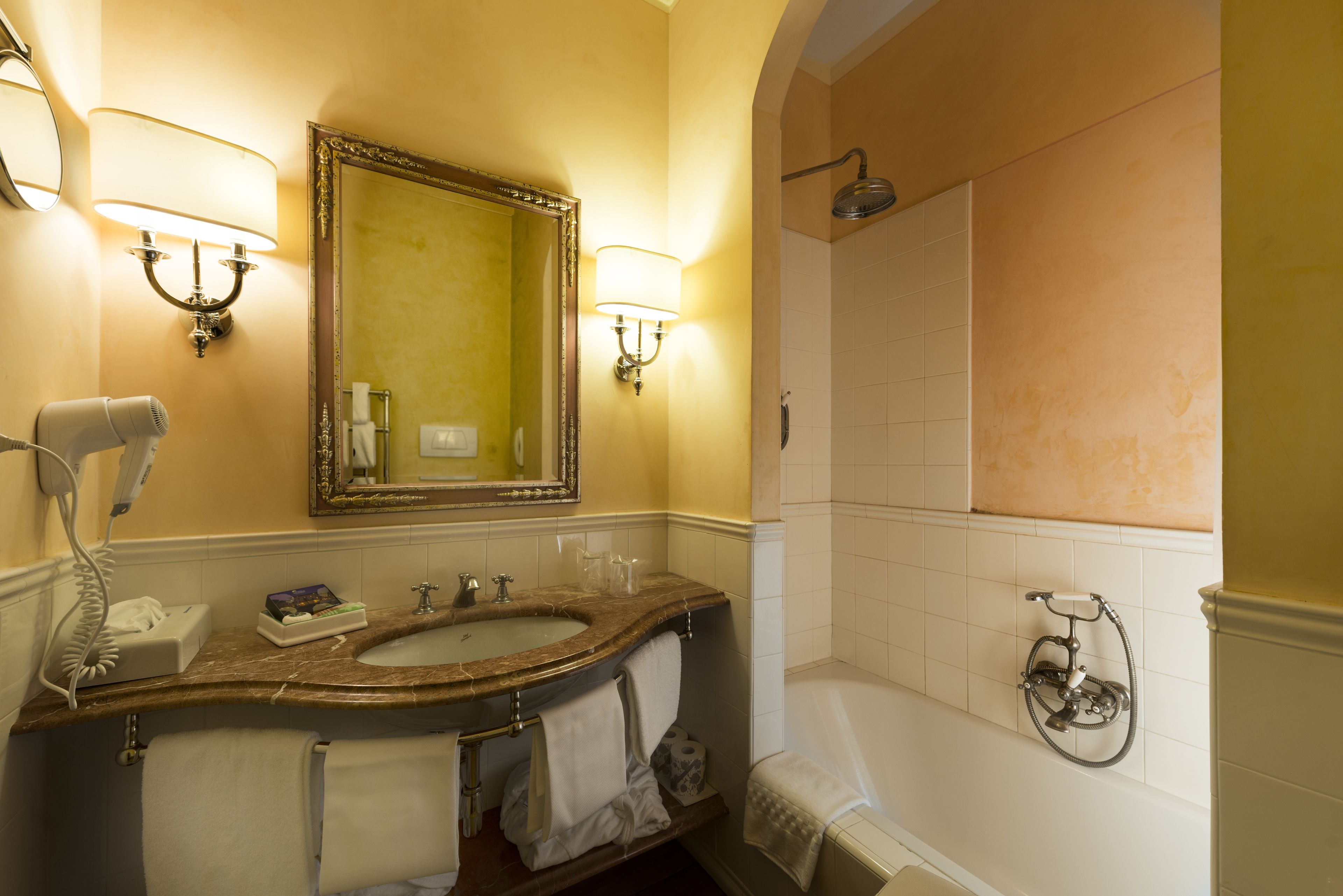 Une salle de bain équipée d’un lavabo, d’un miroir, d’un porte-serviettes et d’une douche.