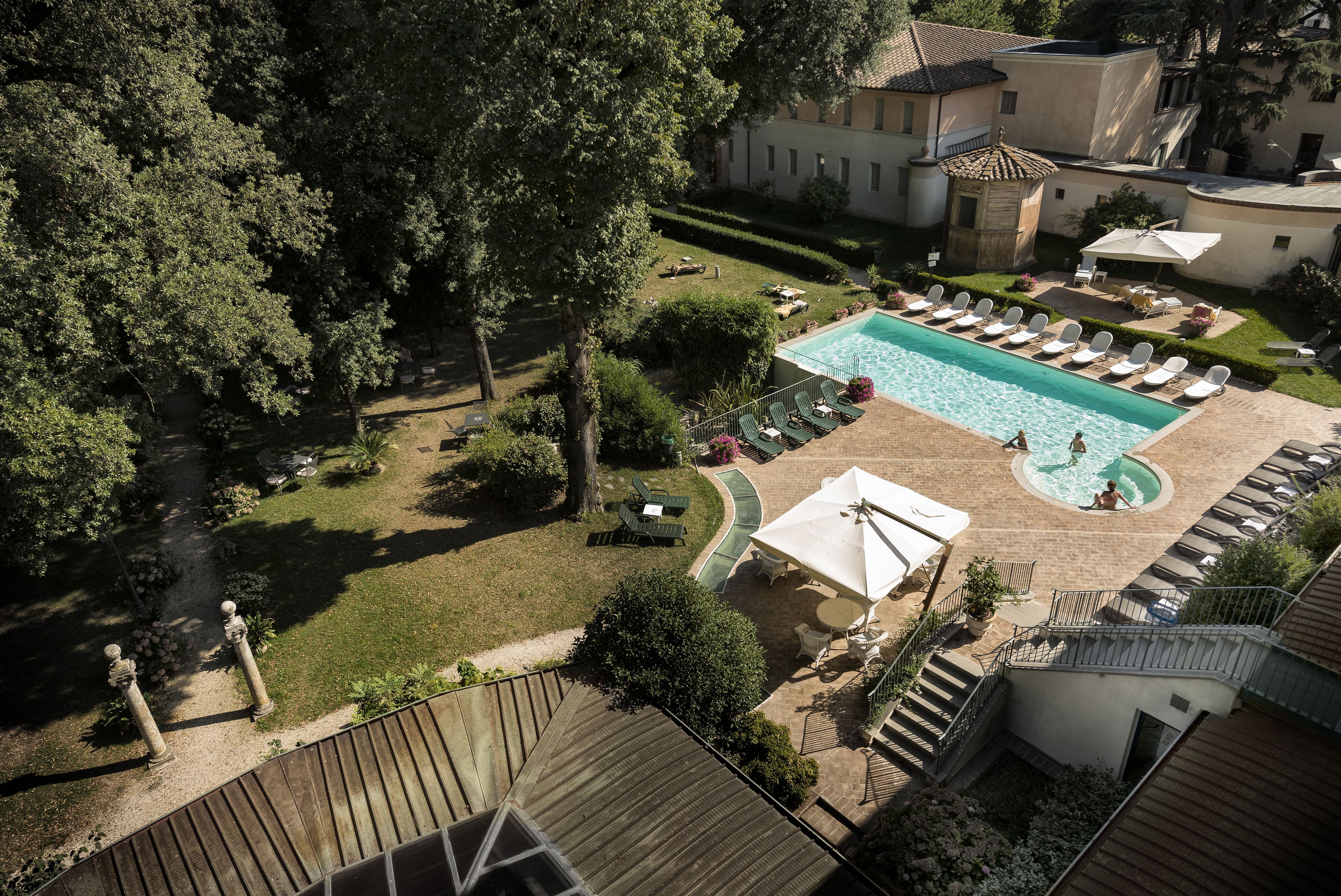 Ein Poolbereich mit Liegestühlen und einer kleinen Whirlwanne.